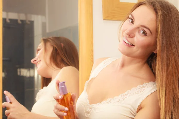 Mujer cuidando su cabello largo aplicando aceite cosmético — Foto de Stock