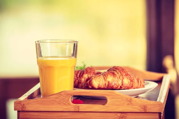 Colazione sul tavolino, croissant al succo d'arancia — Foto Stock