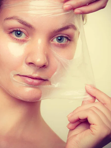 Kvinna att ta bort facial peel off mask. — Stockfoto