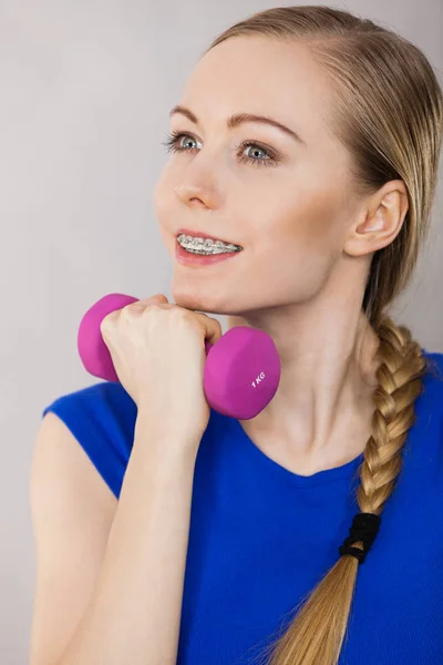 Teenage woman working out at home with dumbbell — Stock Photo, Image