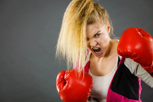 Angry woman wearing boxing gloves — Stock Photo, Image