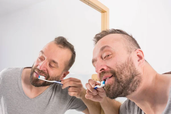 浴室で彼の歯を磨く男 — ストック写真