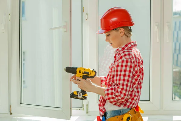 Woman using drill on window — Stock Photo, Image