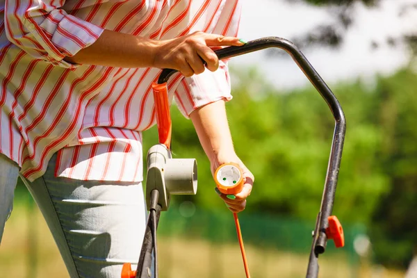 Frau mäht Rasen mit Rasenmäher — Stockfoto