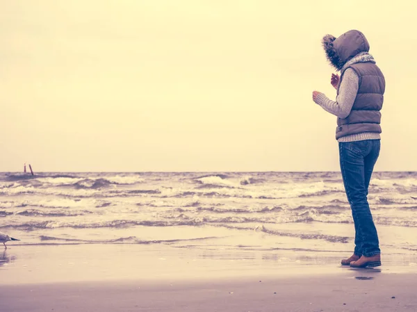 Frau spaziert am Strand, herbstlicher kalter Tag — Stockfoto