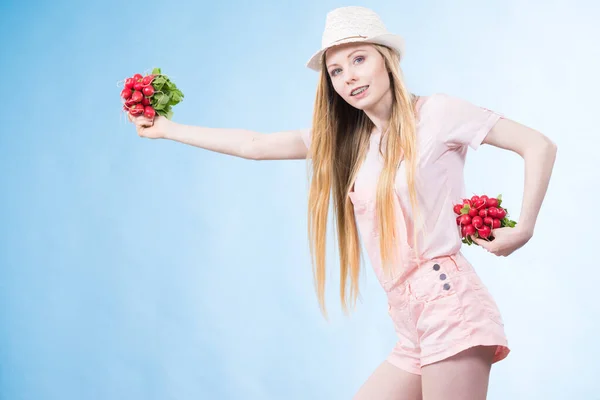 Mladá žena hospodářství ředkvičky — Stock fotografie