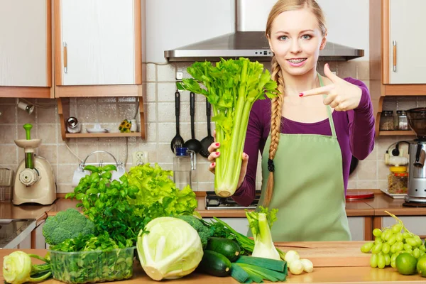 Žena v kuchyni má zelený celer — Stock fotografie