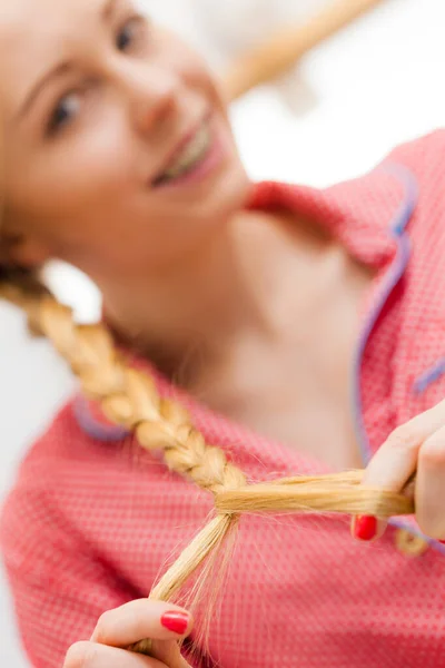 Крупный план женщины, делающей косы на светлых волосах — стоковое фото