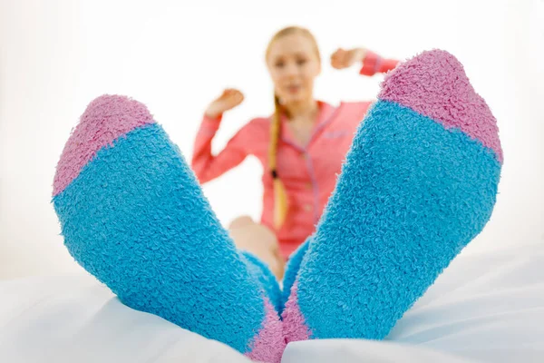 Žena v pyžamu na sobě furry teplé ponožky — Stock fotografie