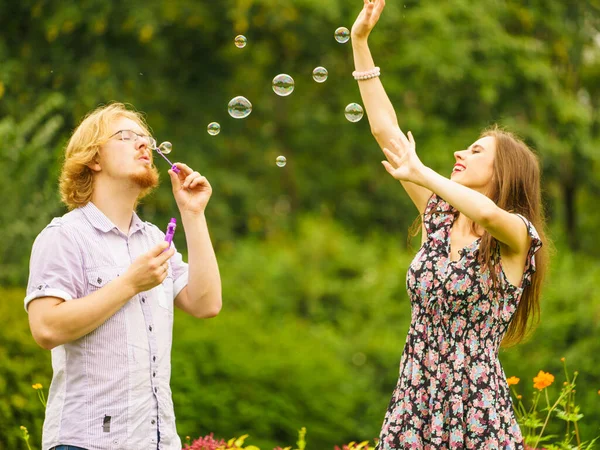Pareja soplando burbujas al aire libre — Foto de Stock