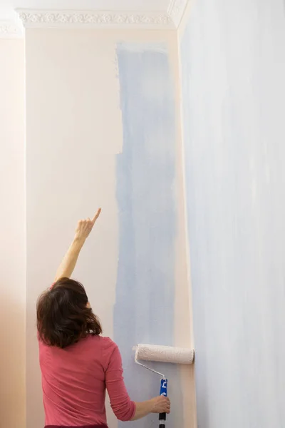 Kvinna som ansöker måla på väggen — Stockfoto