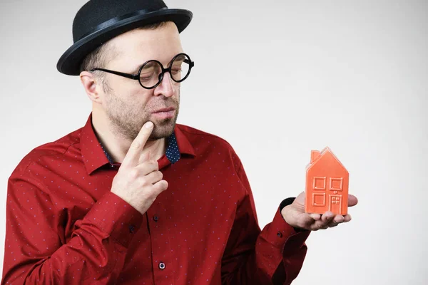 Man wearing funny eyeglasses holding house — Stock Photo, Image