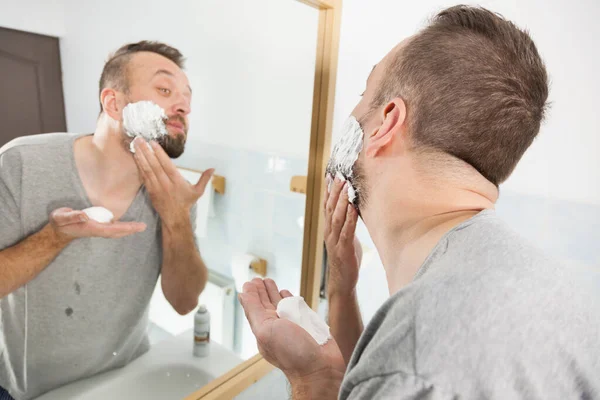 Man tillämpar rakkräm på skägg — Stockfoto