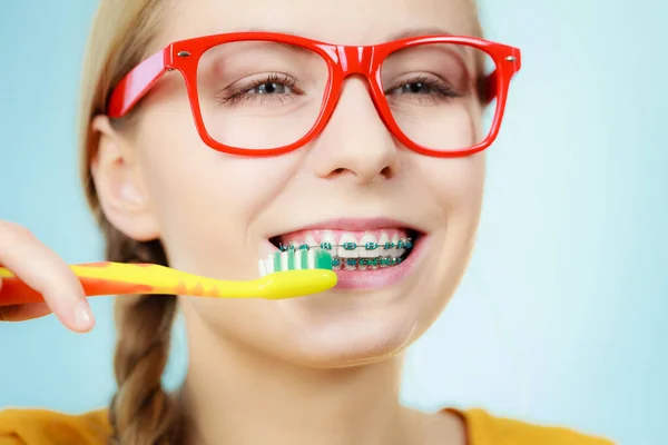 Kobieta z szelkami zębów za pomocą pędzla — Zdjęcie stockowe