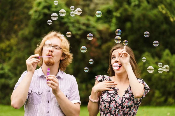 Pár foukání mýdlové bubliny, baví — Stock fotografie