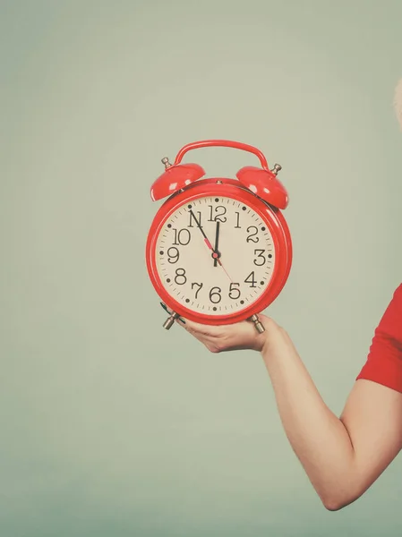 Женщина держит старые красные большие часы — стоковое фото