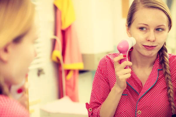 Mulher usando escova de limpeza facial no rosto — Fotografia de Stock