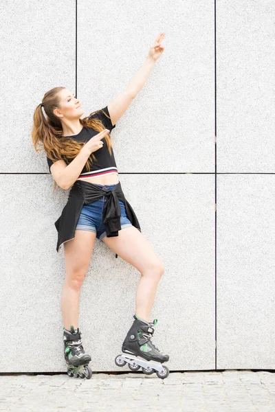 Jonge vrouw paardrijden rolschaatsen — Stockfoto