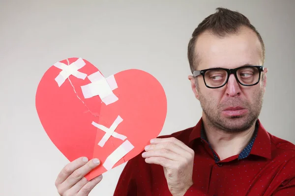 El hombre gracioso sostiene el corazón roto —  Fotos de Stock