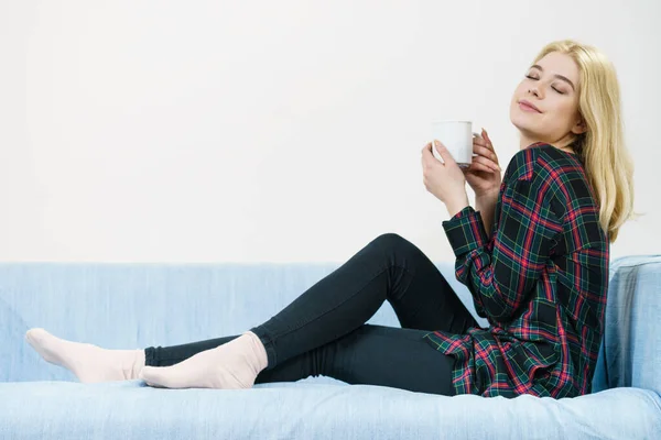 Adolescente sentada en sofá con taza — Foto de Stock