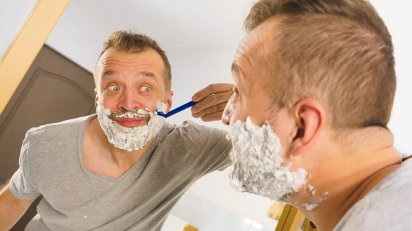 Guy shaving his beard in bathroom — Stock Photo, Image