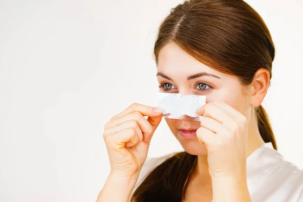 Kvinna ansöker por remsor på näsan — Stockfoto