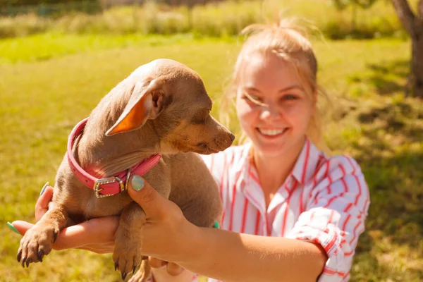 Woman playing pinscher ratter dog outside — Stock Photo, Image