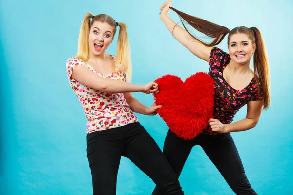 Felice due donne che tengono il cuscino a forma di cuore — Foto Stock