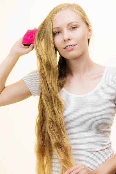 Chica rubia cepillándose el pelo largo — Foto de Stock