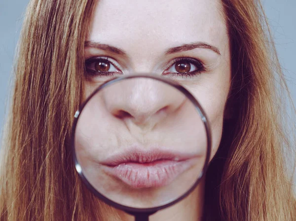 Женщина показывает губы в лупу — стоковое фото