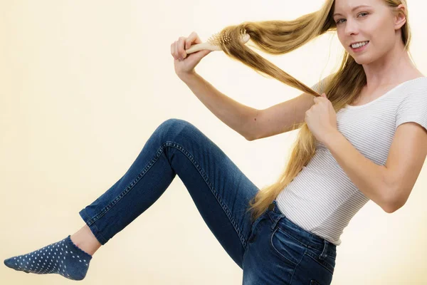 Chica rubia cepillándose el pelo largo —  Fotos de Stock