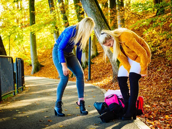 Две женщины меняют обувь в осеннем парке — стоковое фото