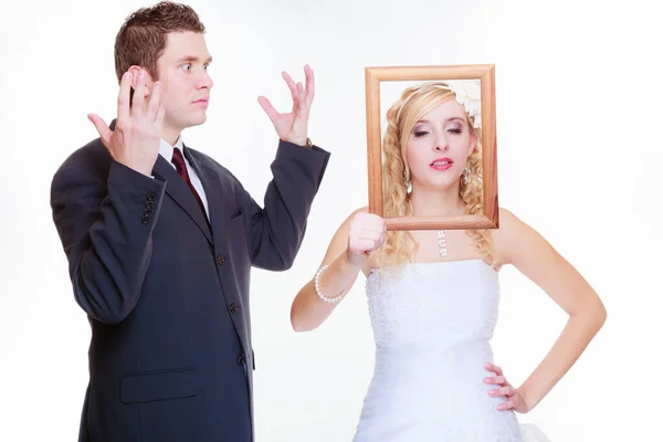 Sposo arrabbiato e sposa in possesso di cornice vuota — Foto Stock