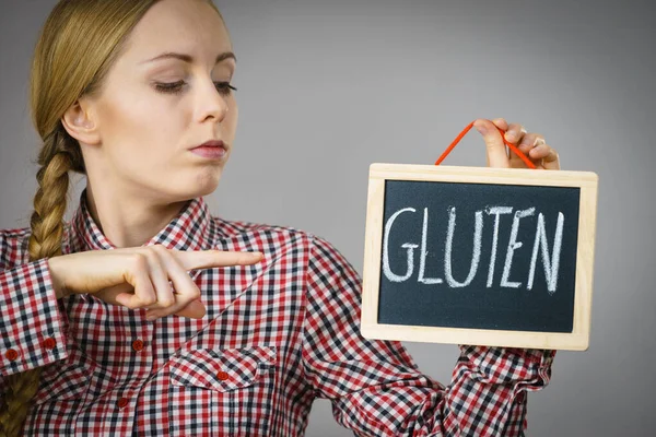 Woman holding board with gluten sign