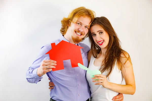 Casal segurando símbolos de papel imobiliário — Fotografia de Stock