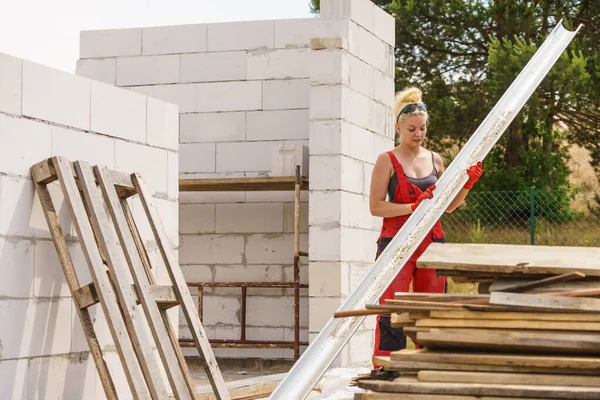 Жінка, що носить жолоб на будівельному майданчику — стокове фото