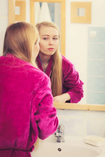 Woman looking at her reflection in mirror — Stock Photo, Image