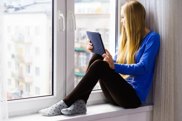 タブレットの窓辺に座っている学生の女の子 — ストック写真