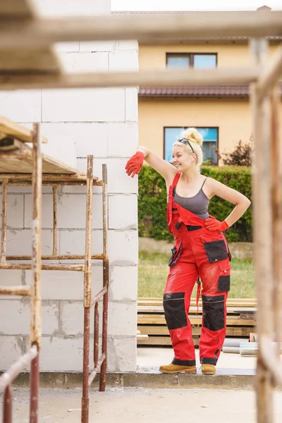 Frau in Latzhose arbeitet auf Baustelle — Stockfoto
