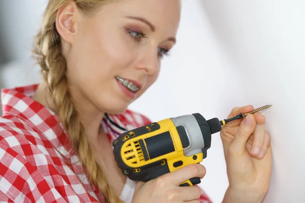 Frau bohrt in Wand — Stockfoto