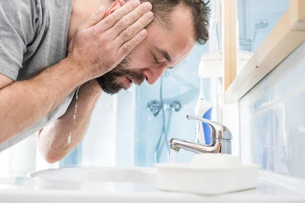 Man washing his face in bathroom — Stock Photo, Image