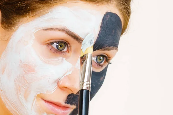 Kız siyah maske üzerinde yarım yüz uygulamak beyaz çamur — Stok fotoğraf