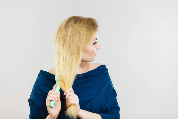 Mulher escovando seu cabelo longo com escova — Fotografia de Stock