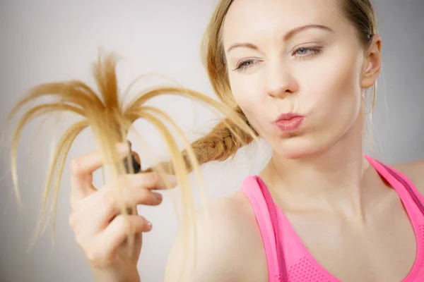 Donna felice guardando le estremità dei capelli — Foto Stock