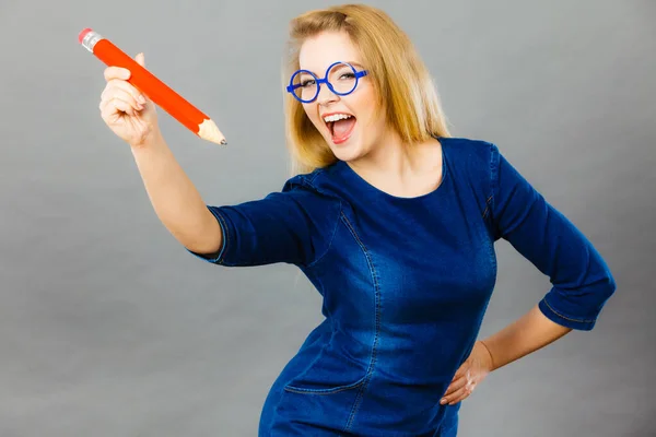 Mulher feliz segurando grande lápis de grandes dimensões — Fotografia de Stock