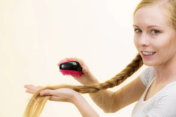 Blondes Mädchen mit langem Zopf hält Pinsel in der Hand — Stockfoto