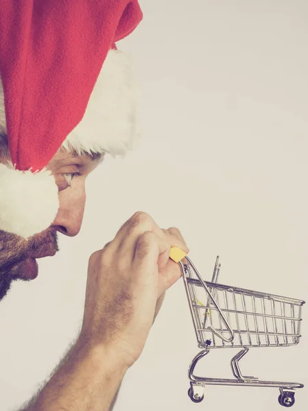 Man in santa hat holds empty shopping cart — Stock Photo, Image