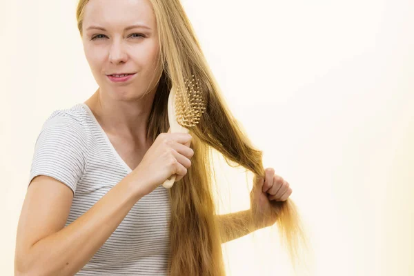 Menina loira escovando seu cabelo longo — Fotografia de Stock