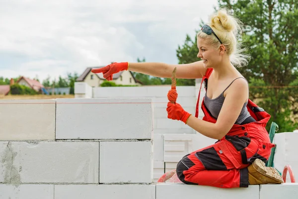 Vrouw met behulp van string als niveau in de muurbouw. — Stockfoto