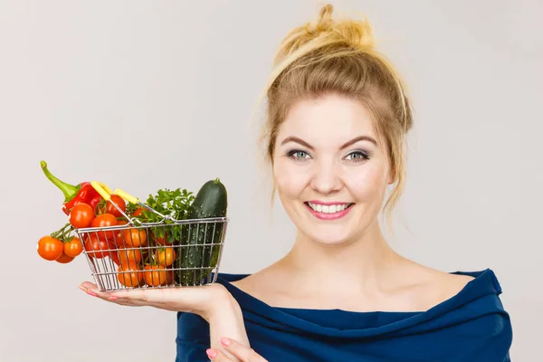 Femme tient panier avec des légumes — Photo